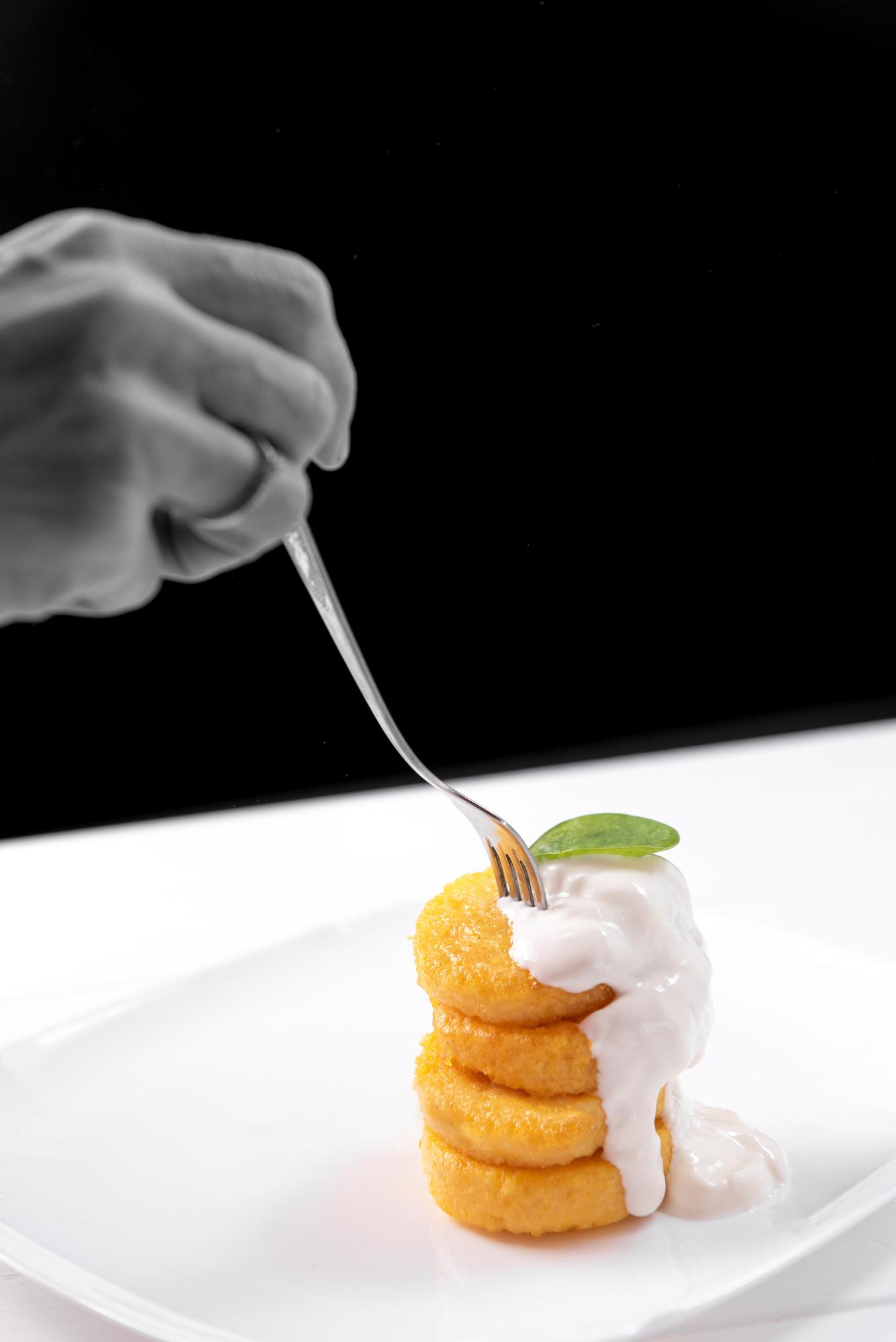 Chef preparing a modern plated dish with neon lighting